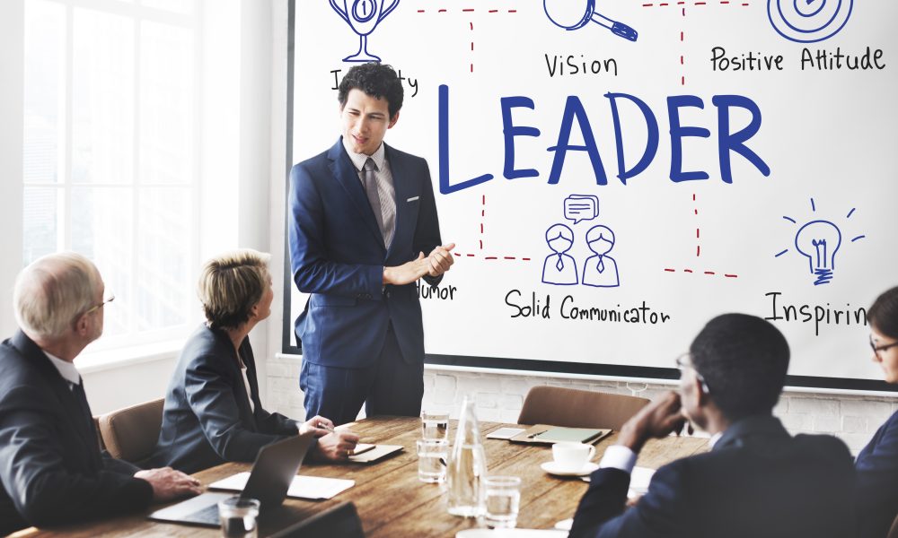 Business meeting discussing leadership qualities at a conference room with a presenter and attentive audience