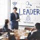Business meeting discussing leadership qualities at a conference room with a presenter and attentive audience