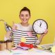 Person smiling and holding a clock, surrounded by sticky notes, coffee cups, and office items on a yellow background