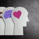 Illustration of three human profiles showing gears, a brain, and a heart, symbolising mind, thought, and emotion