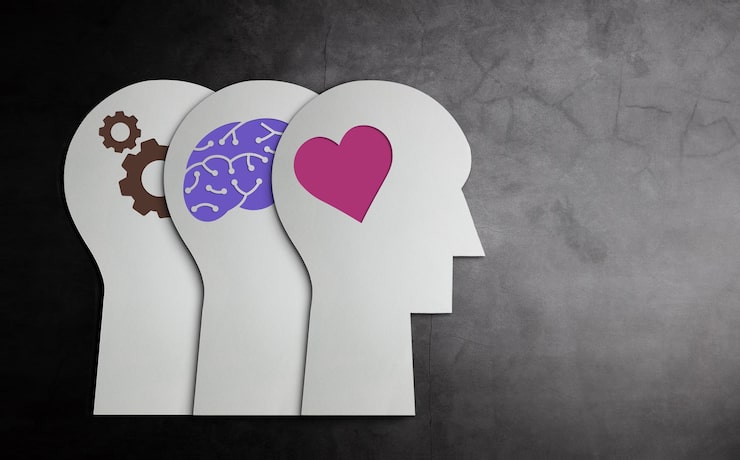 Illustration of three human profiles showing gears, a brain, and a heart, symbolising mind, thought, and emotion